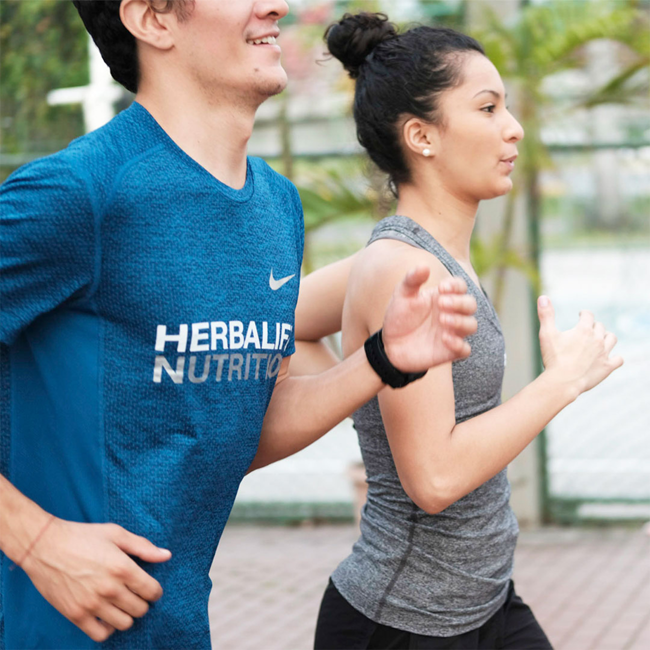 El entrenador de Herbalife Nutrition y su cliente corriendo juntos al aire libre