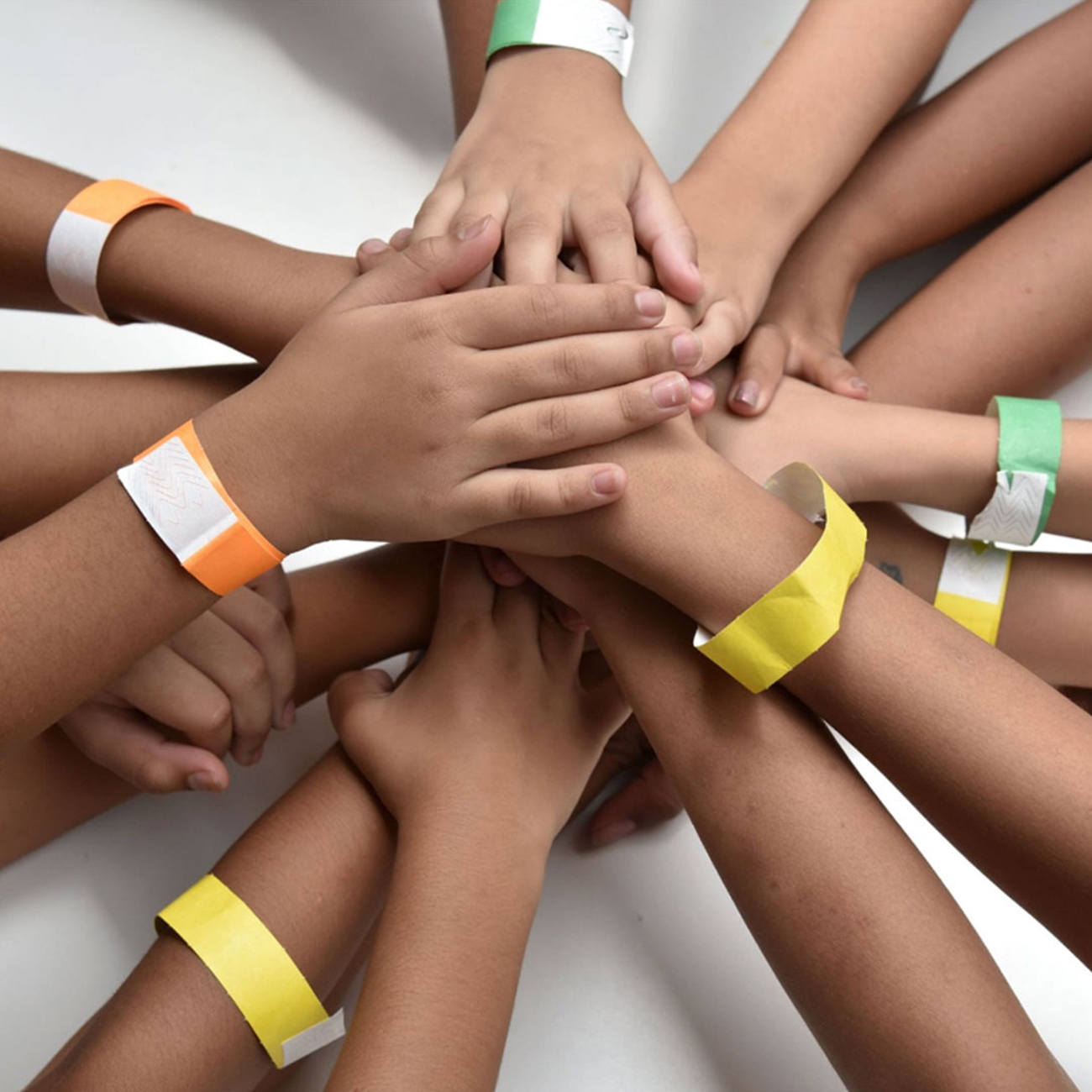 grupo de niños de la fundación Herbalife Nutrition con las manos apiladas una encima de la otra