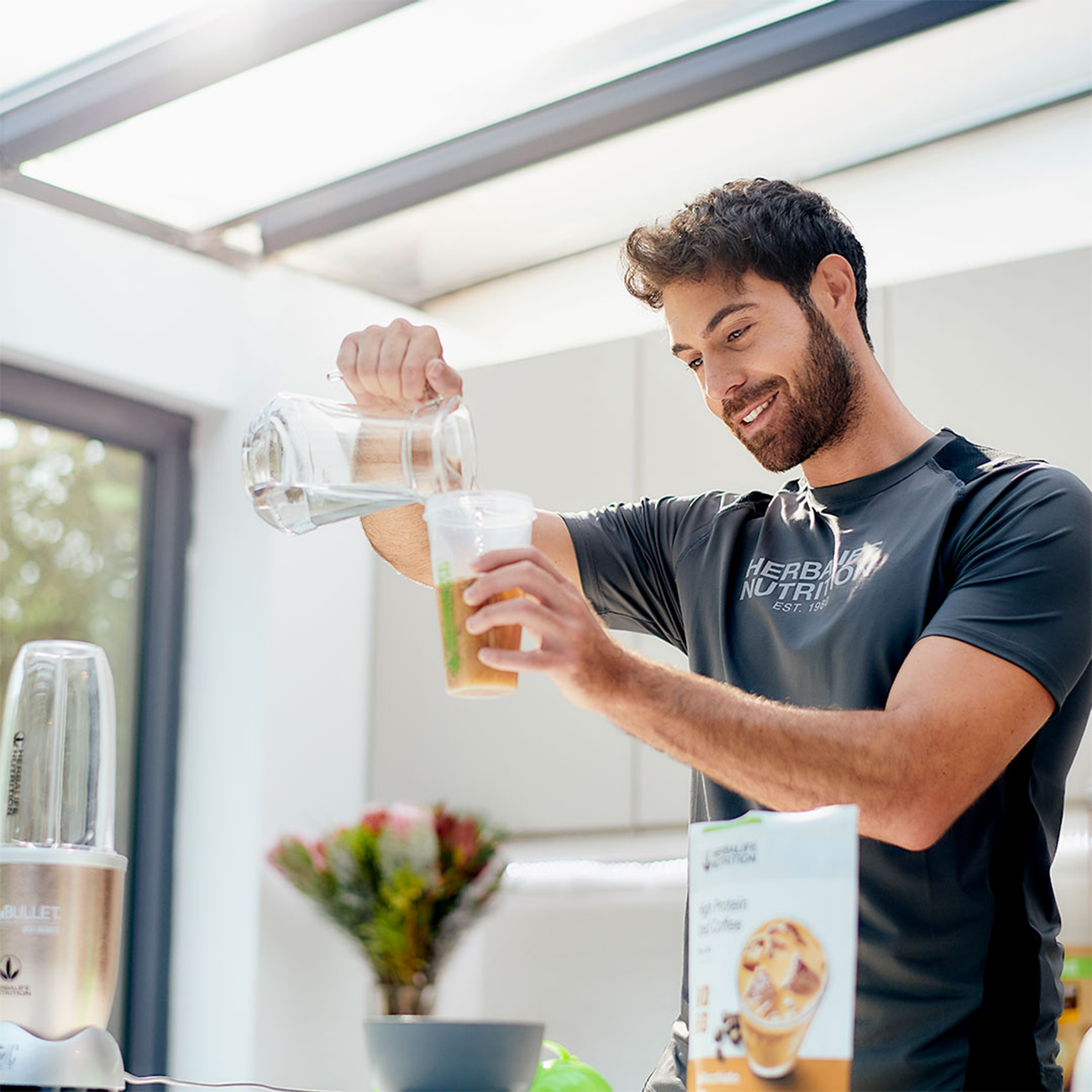 Hombre vertiendo café helado de alto contenido de proteínas en un vaso